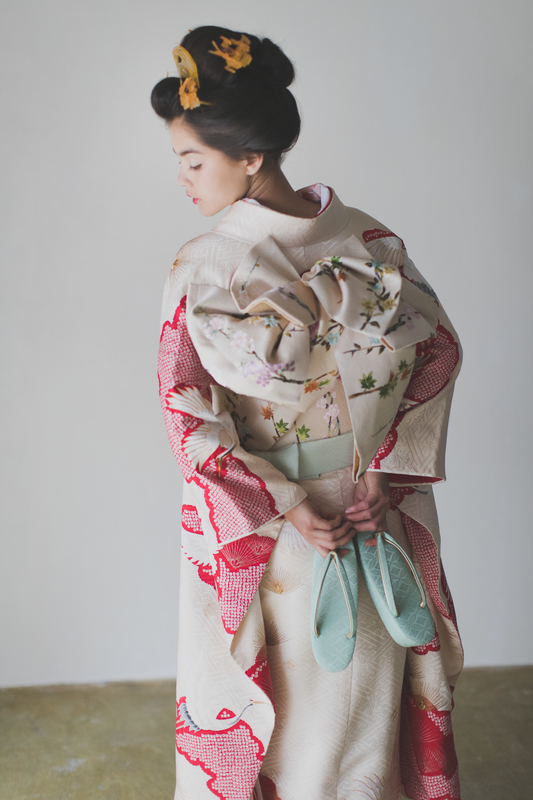 きなりがかった白地の引き振袖で春色コーディネート。帯のお花が可愛らしく、春にもぴったり。